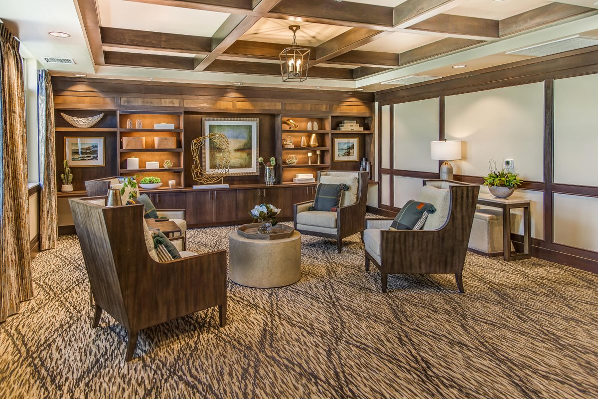 A cozy modern living room with wooden furniture and a library.