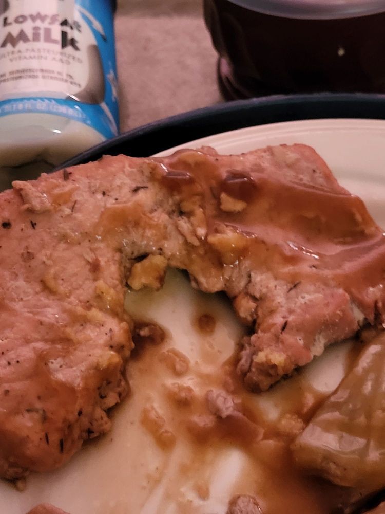 A slice of meatloaf covered in sauce on a plate.