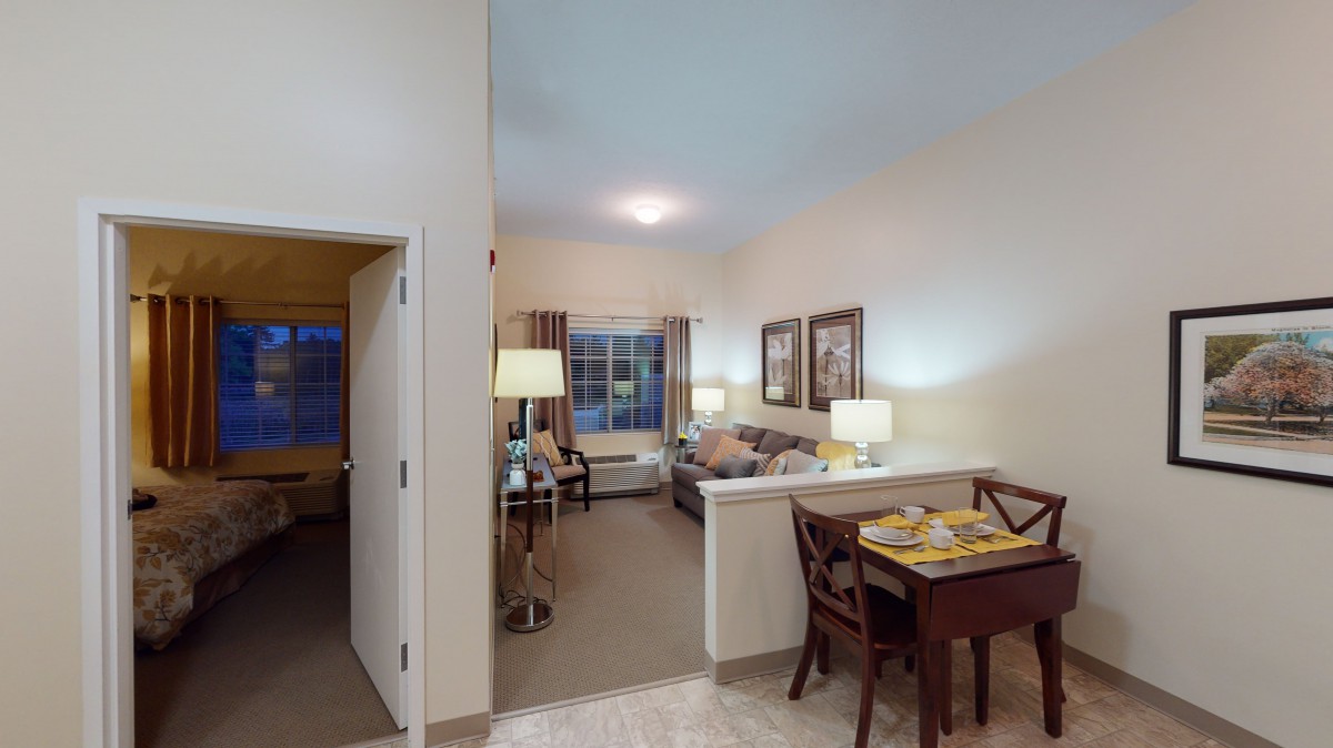 A cozy living space with a dining area, featuring comfortable seating, a table, and ambient lighting.