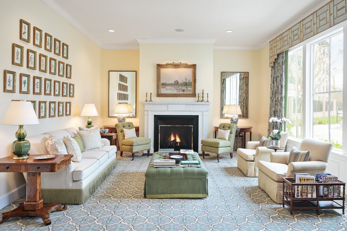 A cozy and elegantly designed living room featuring a central fireplace, surrounded by comfortable seating and tasteful artwork.