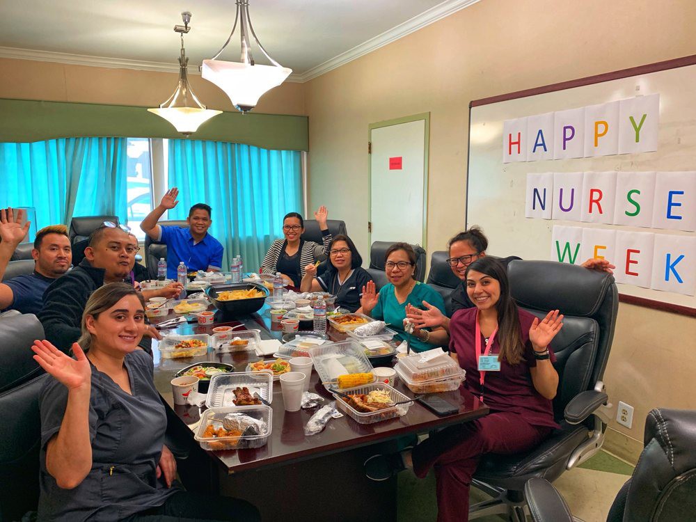 Group of nurses celebrating with a meal during Nurses Week in an office setting.