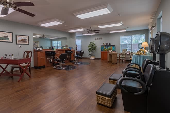 A modern salon interior featuring hair styling stations, a waiting area, and pedicure chairs.