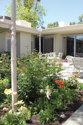 A beautiful garden patio with vibrant flowers and comfortable seating.