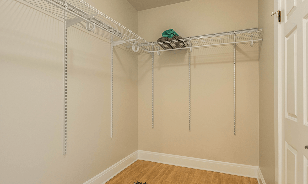 An empty closet with wire shelving and clothes racks.