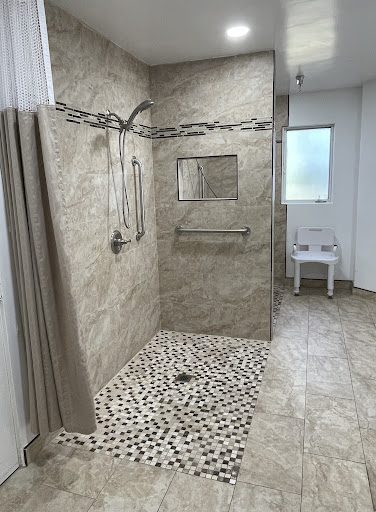 A modern shower area featuring a pebble floor and stylish tile walls.