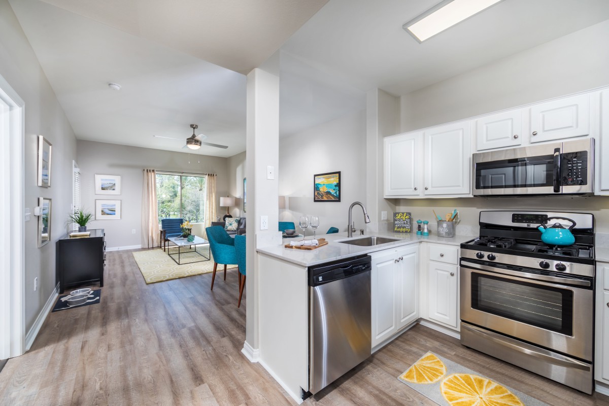 A modern open-concept kitchen and living room with sleek appliances and vibrant decor.