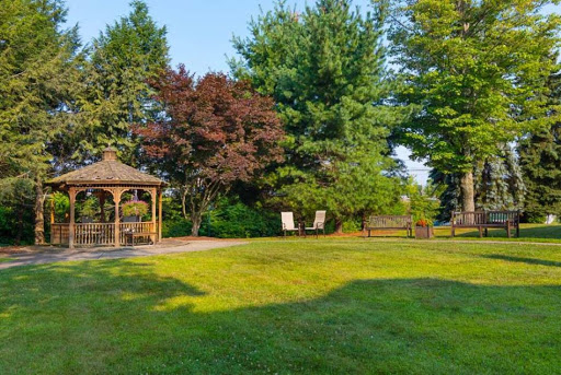 A serene outdoor garden featuring a gazebo surrounded by lush greenery.