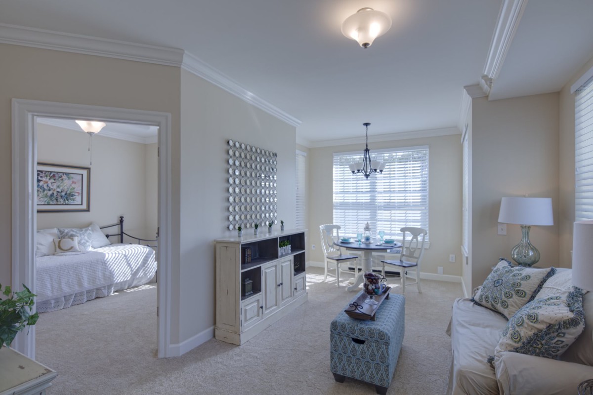 A modern living room with cozy seating, a dining area, and abundant natural light.