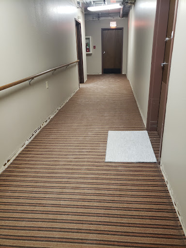 A clean and well-maintained hallway featuring wood-like flooring with a cleaning cloth positioned on the floor.