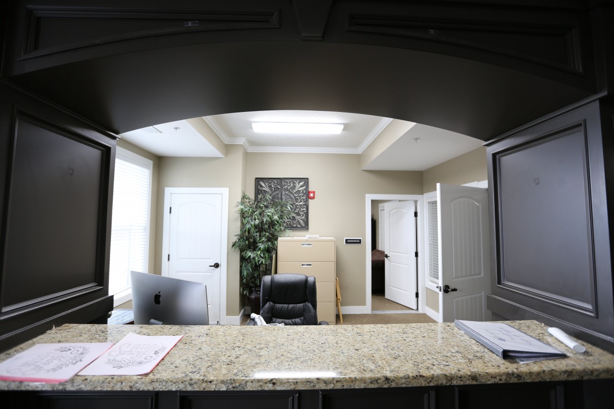A modern office reception area with a desk and computer.