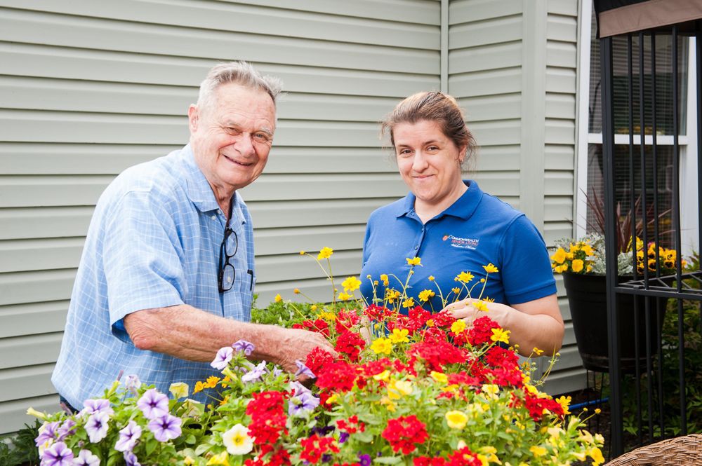 Two people enjoying gardening with vibrant flowers.