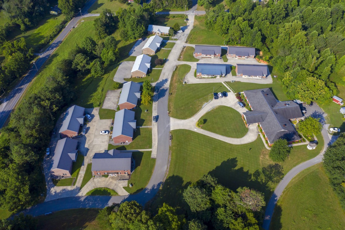 Aerial view of a small residential neighborhood with multiple buildings and greenery.