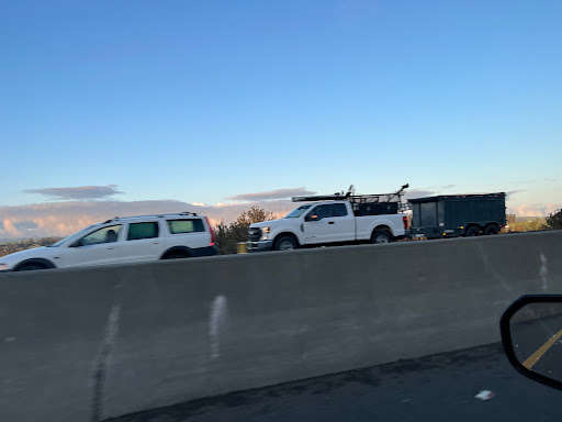 Traffic on the highway with various vehicles under a clear sky.