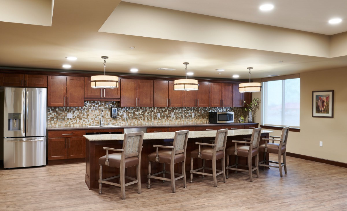 Modern kitchen with wooden cabinets and bar seating.
