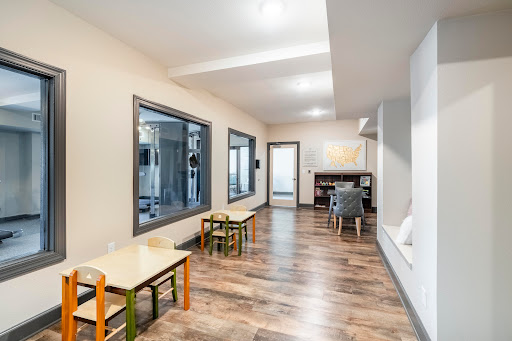 A bright and spacious playroom featuring colorful furniture, designed for child-friendly activities.