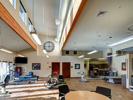 A spacious gym equipped with fitness machines and a seating area.