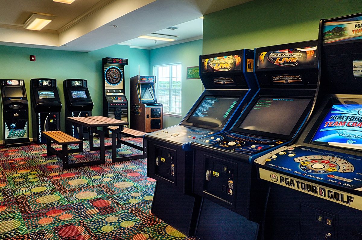A retro-themed arcade room with various classic video game machines.