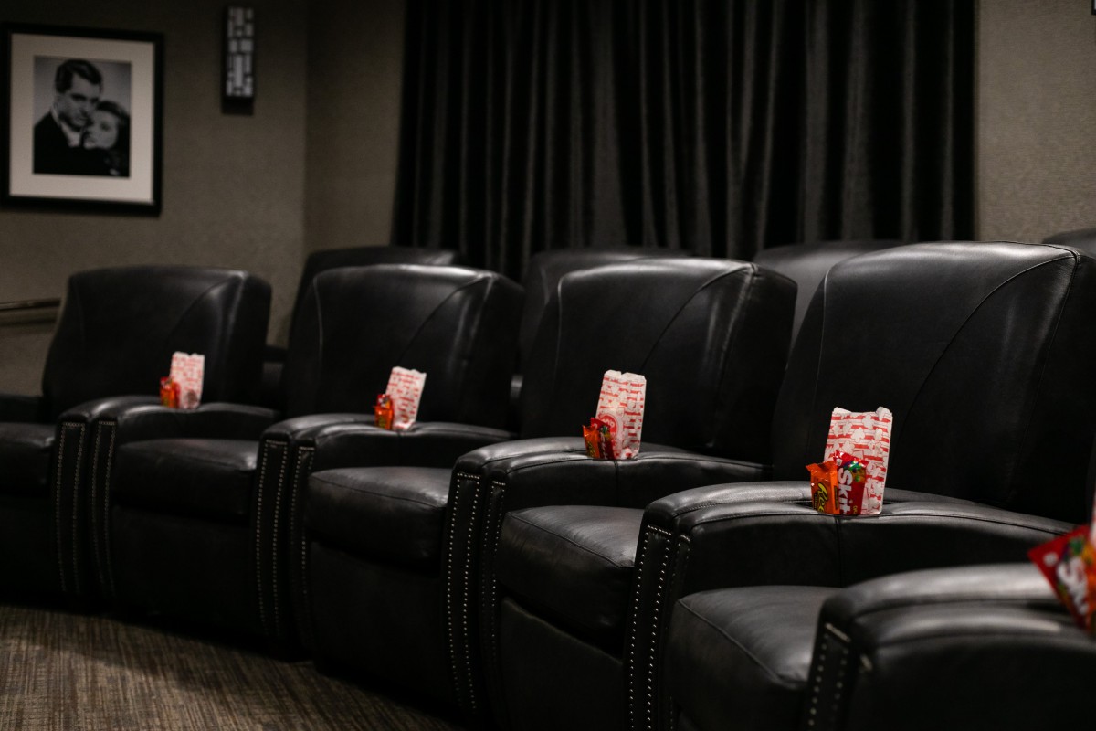 A cozy home theater setup with leather recliners and snacks prepared for a movie night.