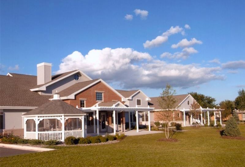 A picturesque residential building under a clear blue sky with scattered clouds.
