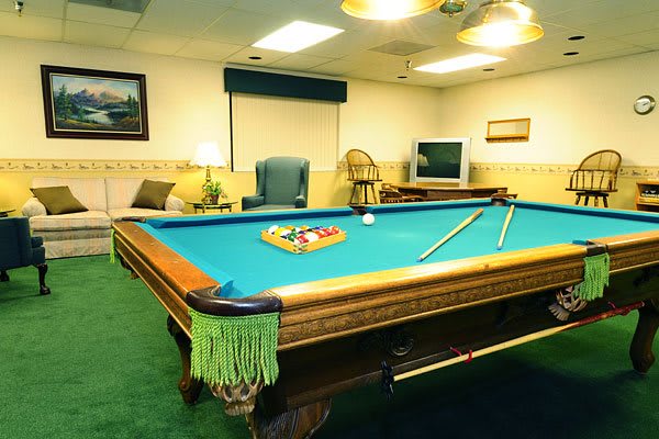 A cozy game room featuring a billiards table ready for a match.