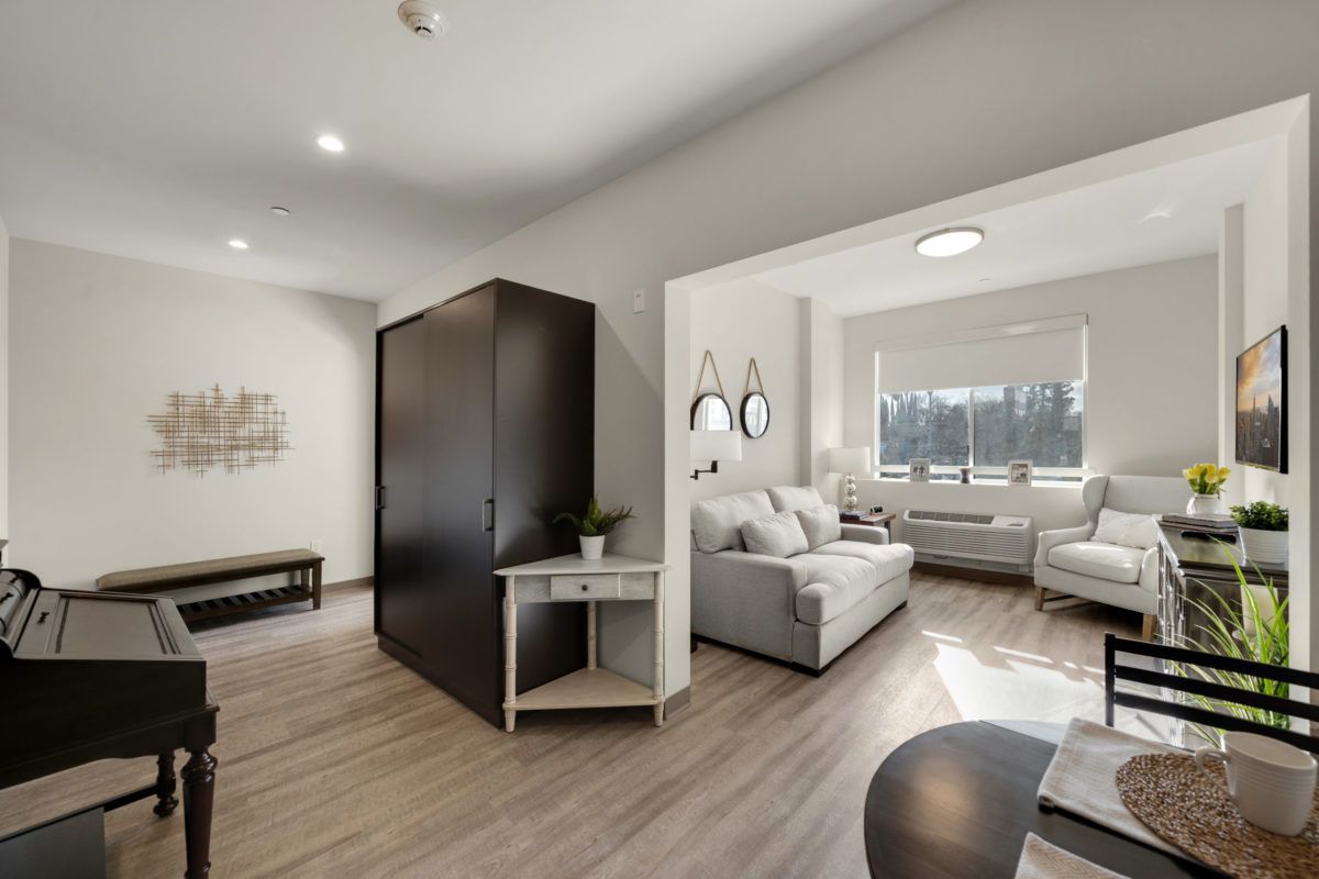 A modern, bright living room with stylish furniture and large windows.