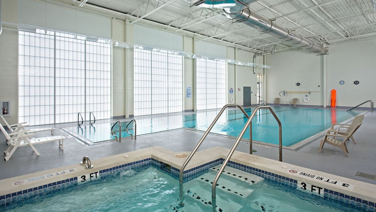 An indoor leisure facility featuring a swimming pool and a hot tub.
