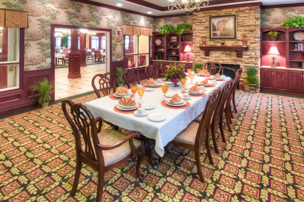 An elegantly set dining room with a long table, ornate chairs, and classic decor.