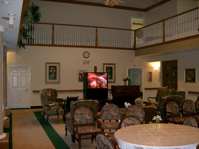 A spacious two-story living room with comfortable seating and a television.