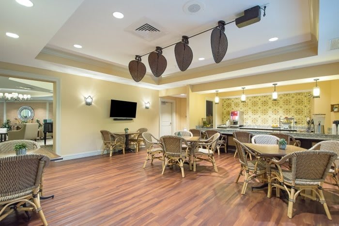 A cozy lounge area with wooden floors, comfortable seating, and a mounted television.