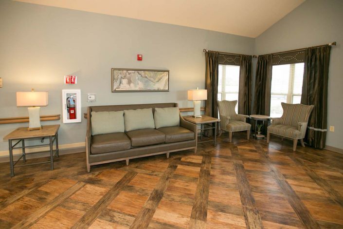 A cozy living room with a sofa, chairs, and wooden flooring.