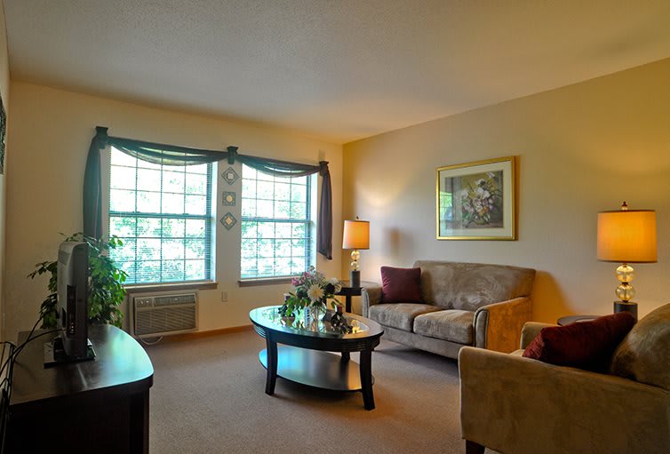 A cozy living room with a large window, comfortable seating, and elegant decor.