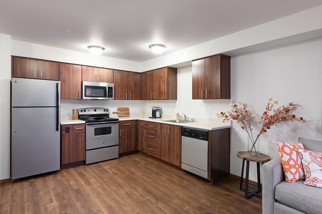 A modern kitchen featuring wood cabinets and stainless steel appliances.