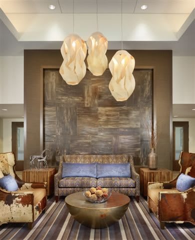 A modern living room with stylish lighting and cozy seating arrangements.