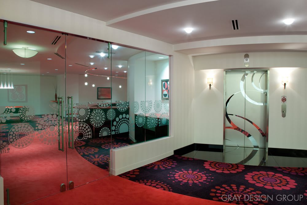 A modern interior space featuring vibrant carpets and glass doors.