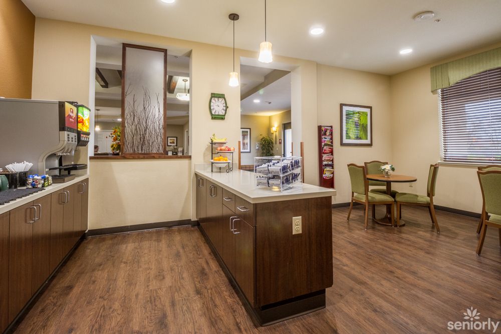 A modern kitchen and dining area with wooden flooring and bright lighting.