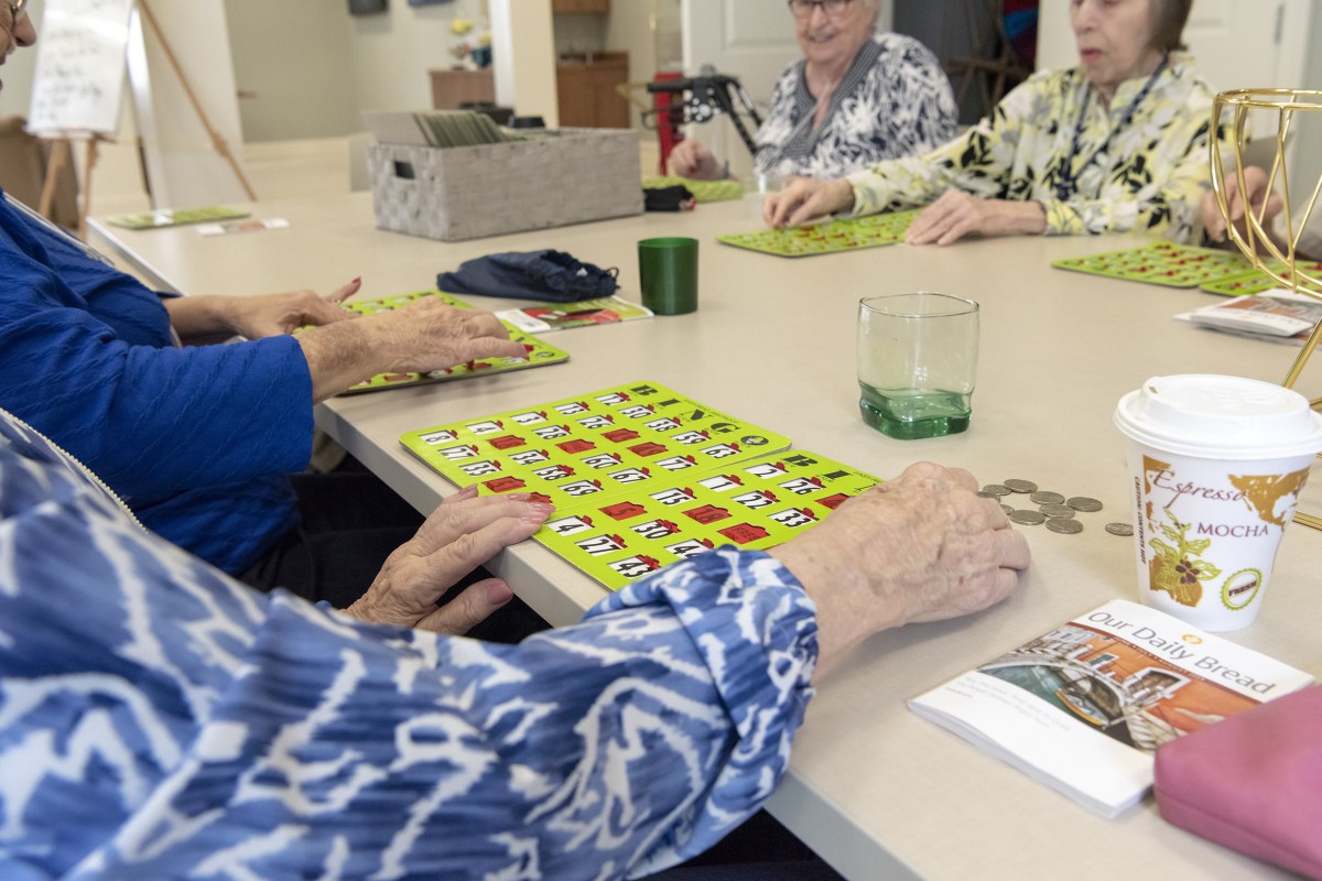 A group of seniors enjoying a game of bingo at a table.