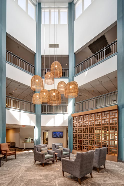 A spacious and modern lobby with a large chandelier and comfortable seating.