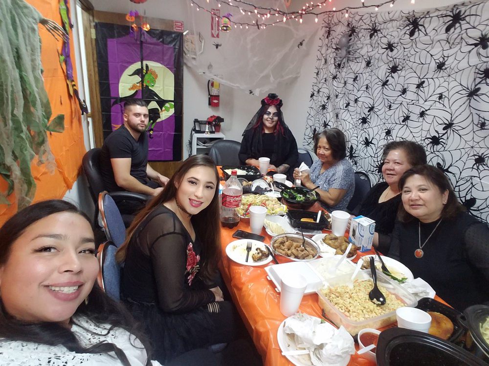 A group of people enjoying a Halloween-themed party with festive decorations and food.