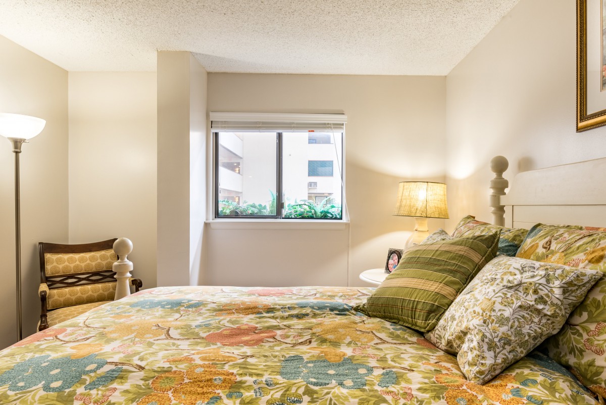 A cozy bedroom with a colorful bedspread and soft lighting.