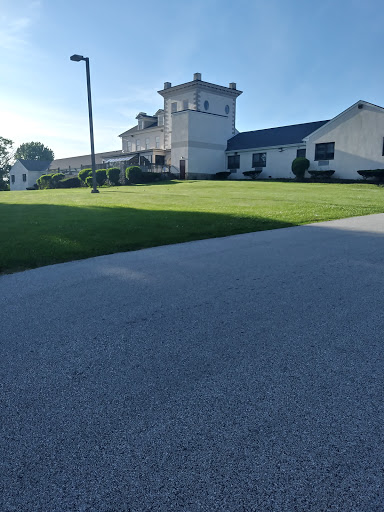 A well-maintained property featuring a distinctive architectural building, surrounded by lush green grass.