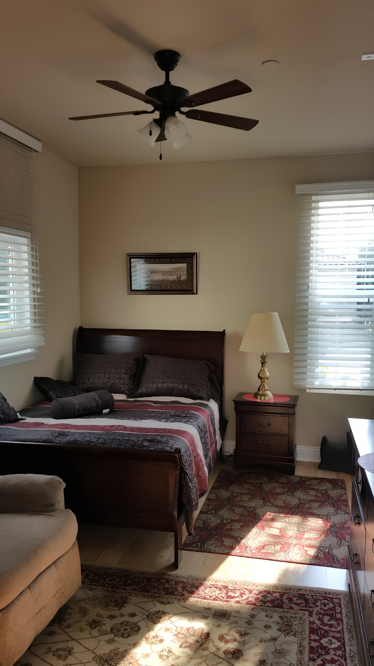 A cozy bedroom with a bed, nightstand, lamp, and window.