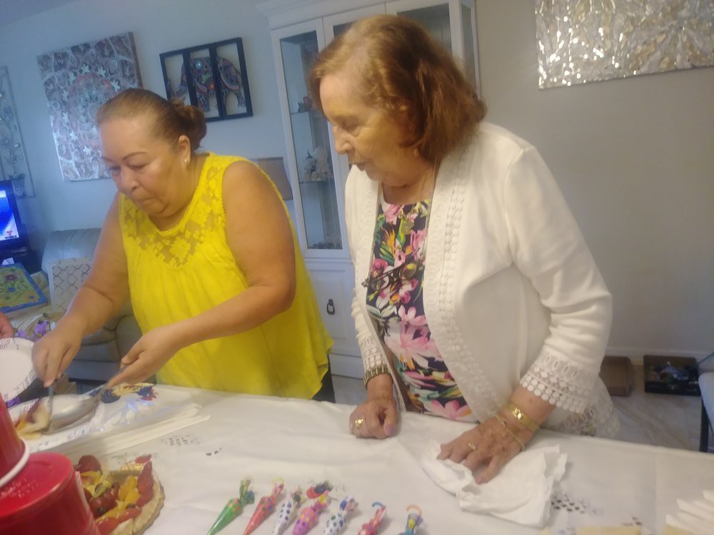 Two women at a table preparing to celebrate with a cake.