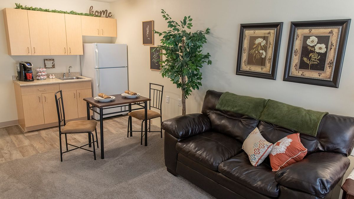Cozy living area with a small dining table and kitchen in view.