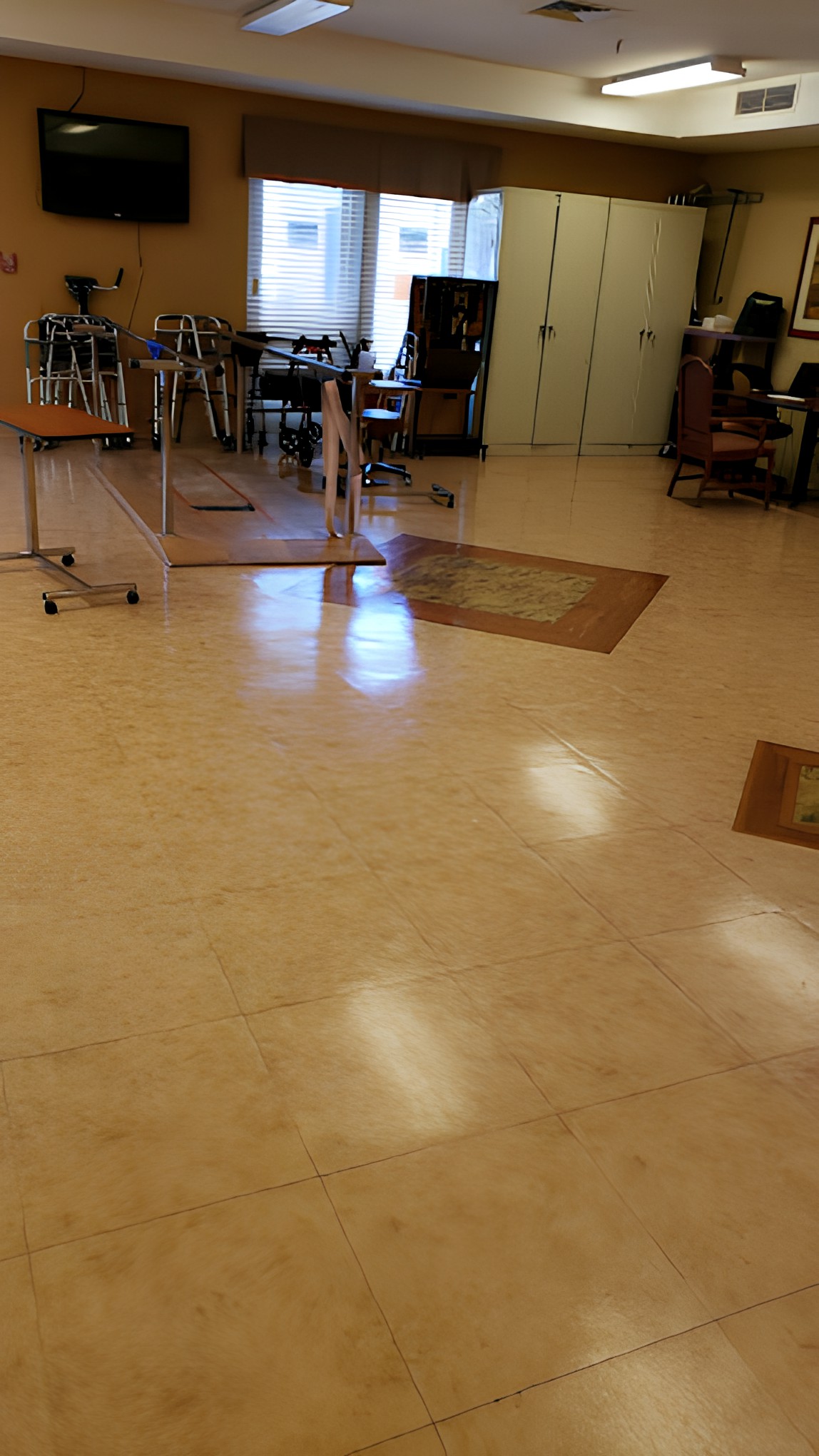 An empty classroom with desks and chairs arranged neatly on a polished floor.