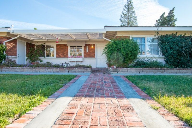A suburban house with a brick pathway leading to the entrance.