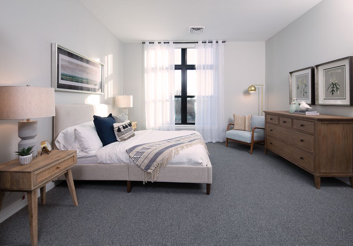 A modern bedroom with neutral tones and stylish furnishings.