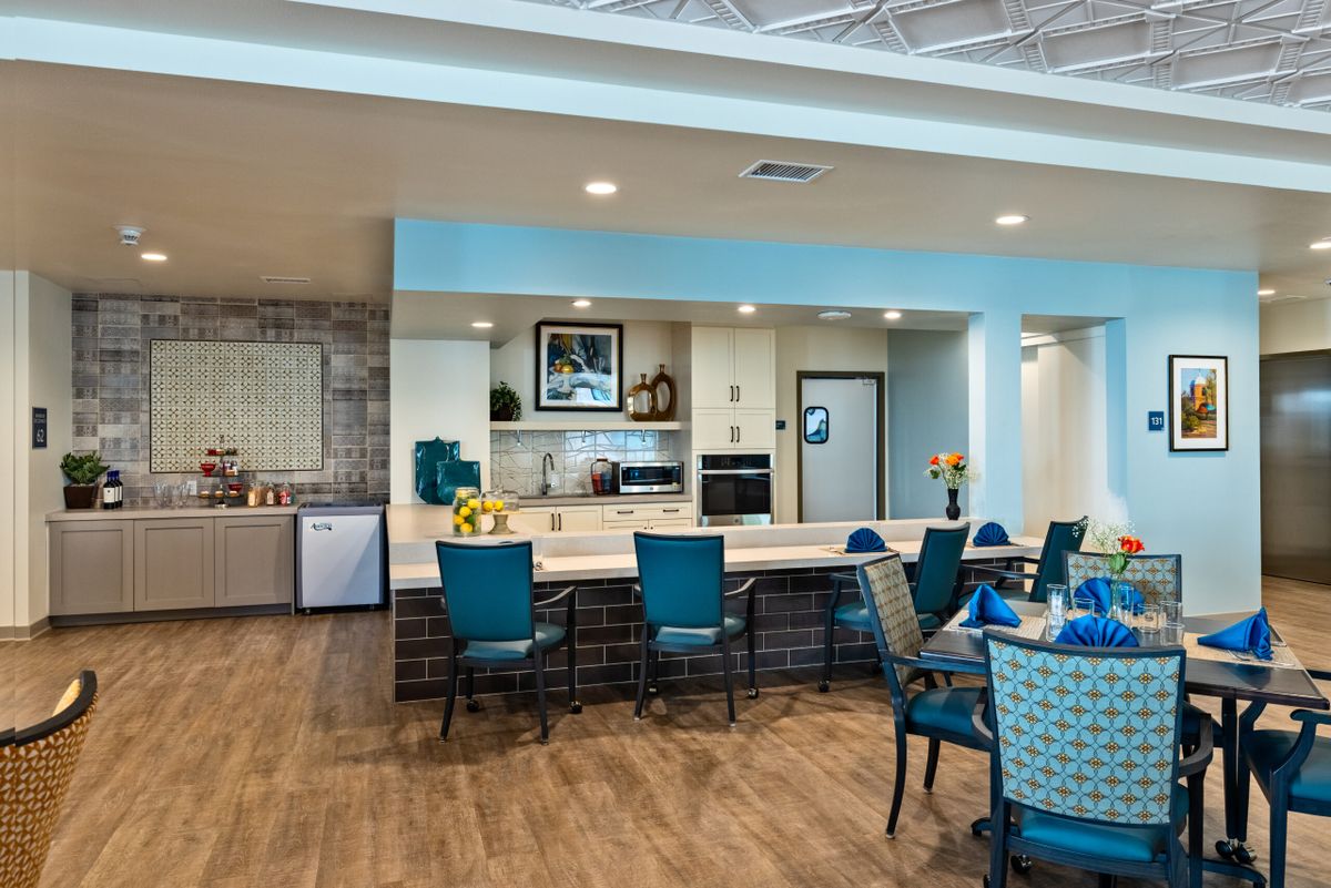 A modern interior dining area with a kitchen and seating arrangement.