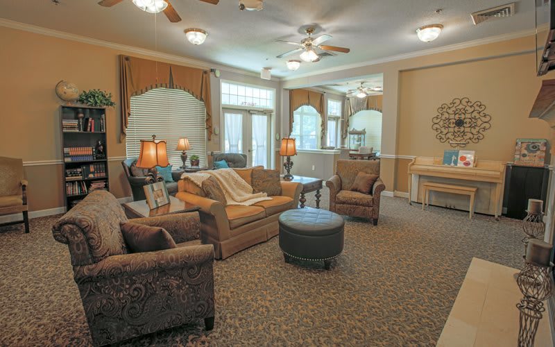 A cozy living room with comfortable seating and ample lighting.