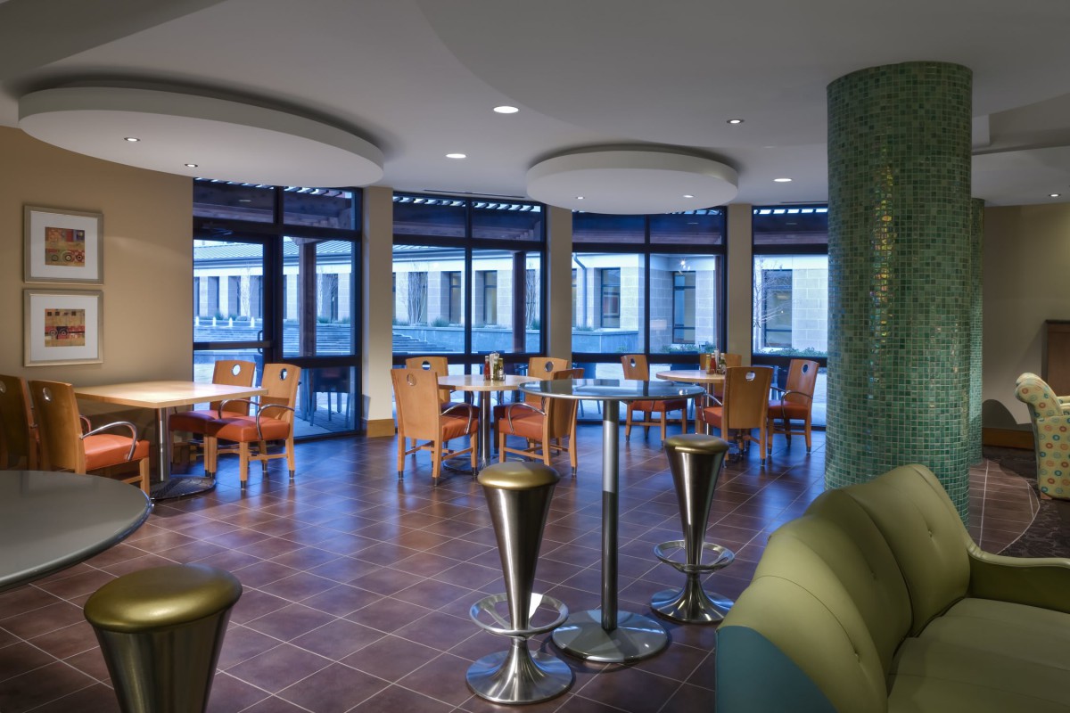 A modern restaurant interior with arranged tables and chairs in an elegant setting.