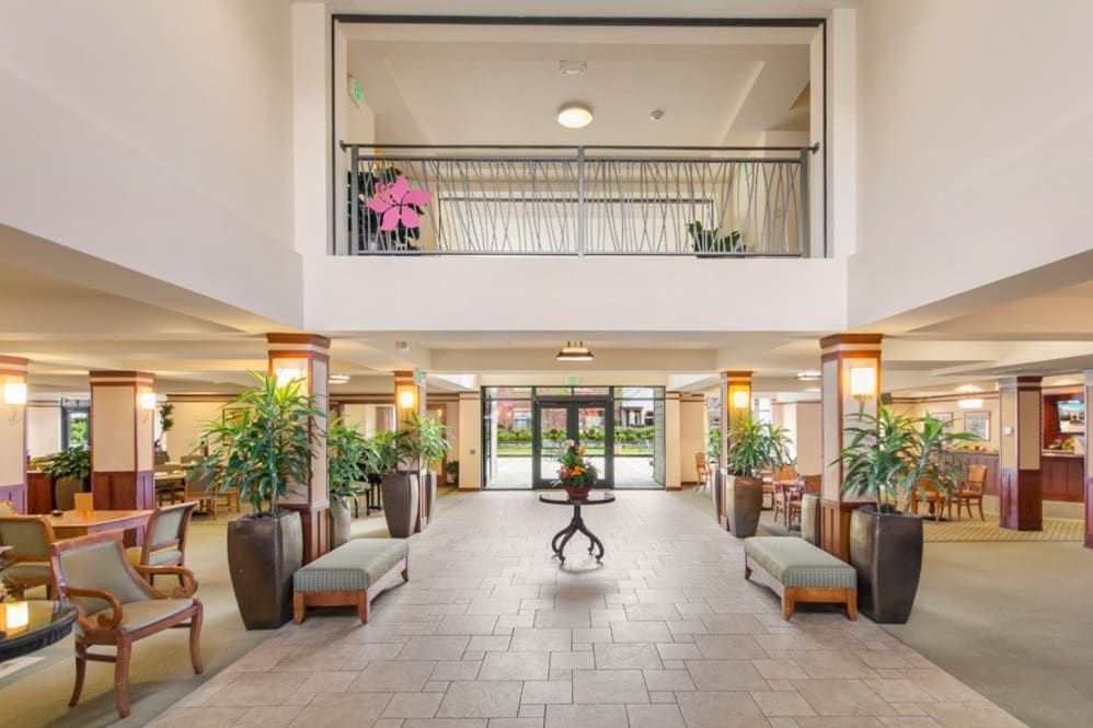 A spacious and well-decorated hotel lobby with plants and seating areas.
